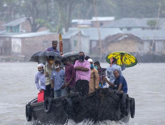 calcuta-ondoan-desastres-naturales Grupo de personas sobre una barca en un día de lluvia intensa para la sección de Ayuda Humanitaria de Calcuta Ondoan