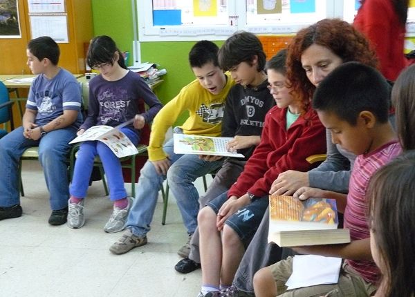 Profesora y alumnos y alumnas revisando material docente para la sección de proyectos 