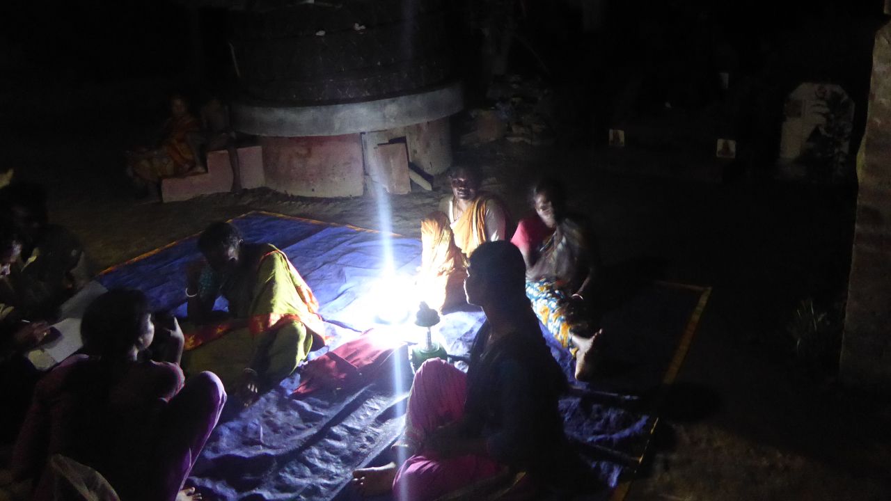 proyectos-mujeres-de-luz-08 Imagen de mujeres sentadas de noche iluminadas con una lámpara de luz para acompañar a la sección del proyecto
